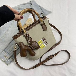 Woodpecker (tucano) niche versatile crossbody bag new fashion woven high-value shoulder bag commuting out portable bucket bag white with brown belt leather puppy pendant